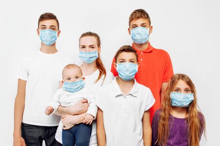 CAVID-19 pandemic coronavirus a young family, parents and children wear a protective mask to protect against viruses, coronavirus disease, on an isolated white backgroundの写真素材