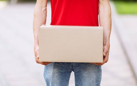 Courier with parcels in hand in the open airの写真素材