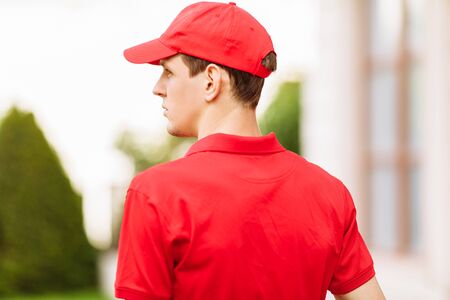 A courier in a red uniform. Fast delivery by transport. Online stores and Express delivery.の写真素材