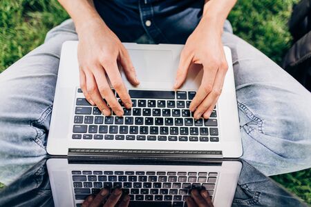 close up of hands typing while working on a laptop