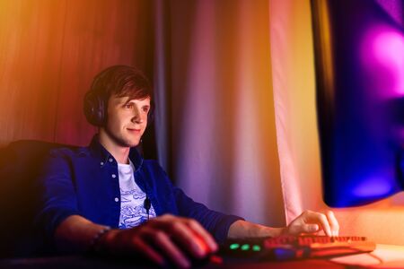 A professional gamer plays online video games in the first person on his personal computer, sitting...