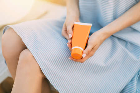 Woman's hands with sunscreen lotionの写真素材