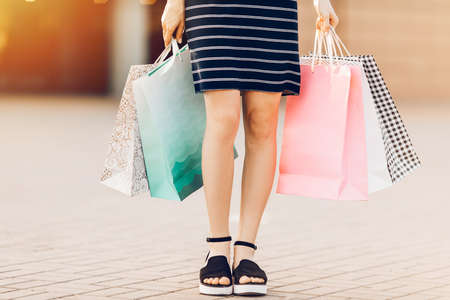 Let's go shopping. woman holds colorful shopping bags on the street against the background of a shopping center. Fashionの写真素材