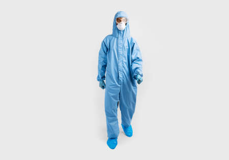 male doctor wears a protective suit to fight the covid-2019 coronavirus pandemic. Protective suit, safety glasses, gloves, respirator, on an white backgroundの写真素材