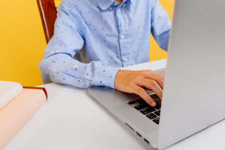 Student hands typing on a laptop keyboard, doing homework, studying at home, distance learning