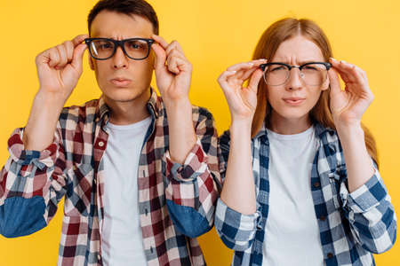 young people, man and woman wearing glasses for vision on yellow backgroundの写真素材