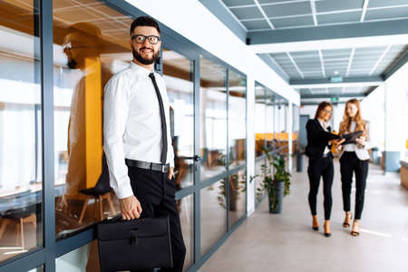 Happy businessman in business clothes in modern office at workの写真素材