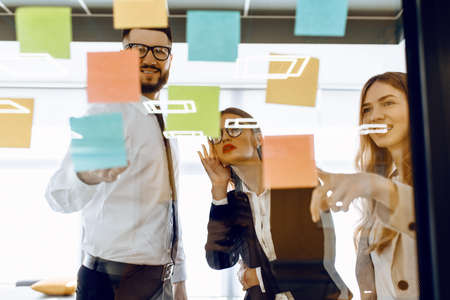 Business colleagues brainstorm with sticky notes at workの写真素材