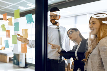 Business colleagues brainstorm with sticky notes at workの写真素材