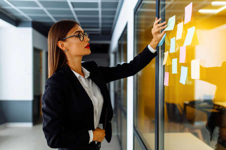 businesswoman brainstorming with sticky notes at work in office