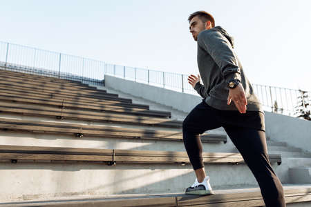 Sporty young man, in sportswear, jogging while training outdoors on the city stairs, sport, healthy...