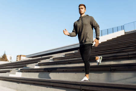 Sporty young man, in sportswear, jogging while training outdoors on the city stairs, sport, healthy...