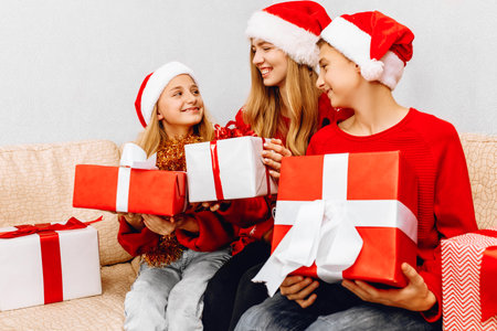 Happy New Year and Merry Christmas! Happy family, a young mother with children, wearing santa claus...