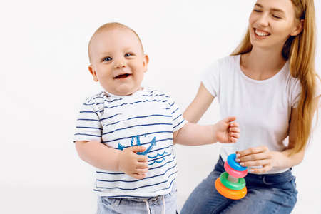 Baby with mom playing with colorful toys, on an isolated white background, Early development