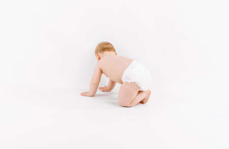 Happy cute little baby in diaper crawling on isolated white backgroundの写真素材