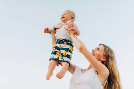 Happy young family have fun on the beach, mother with son play on the beach in summerの写真素材