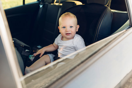 A small child is fastened with a seat belt on the car safety seatの写真素材