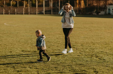 Beautiful happy family having fun and jogging outdoors, mom and baby jogging in the parkの写真素材