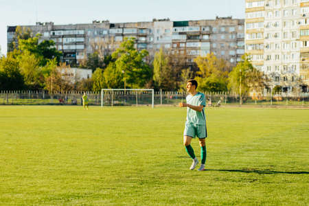 Professional soccer player or soccer player in action at the stadium, hitting the ball to reach the goal, young sporty male soccer player on the soccer field, wide angle, The concept of sports, competition, movement, overcomingの写真素材