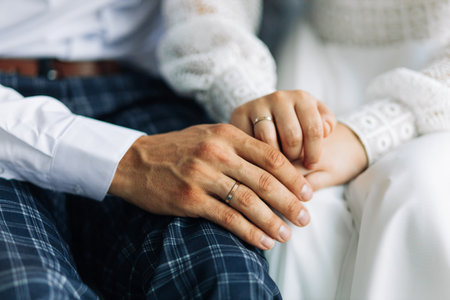 Hands of newlyweds with wedding rings, Young married couple holding hands, wedding day ceremony, Hands of newlyweds with wedding ringsの写真素材