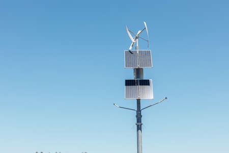 Wind turbines and solar panels, solar panels and wind turbine against blue sky renewable energy conceptの写真素材