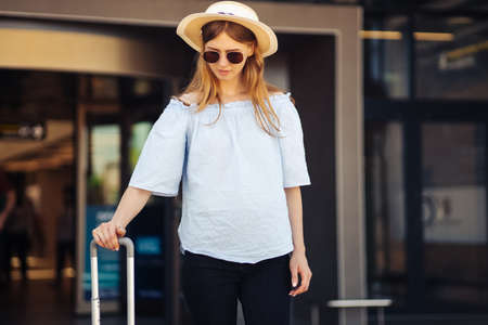 Young woman at the international airport, moves to the terminal gate for travel by plane, travel concept, and aerospace industryの写真素材