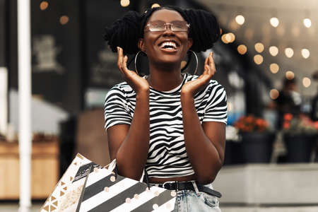 Beautiful african woman smiling and happy while shopping in stores with sales for Christmas, concept, shopping, holidays, Christmasの写真素材