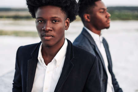 Two trendy African black men, outdoors, in stylish classic clothes, with fashionable hairstyle, Handsome men, model portrait, Fashion concept, mens clothingの写真素材