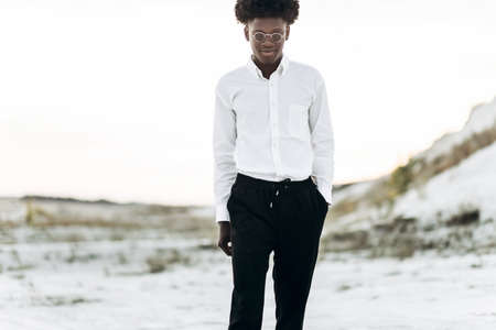 Handsome fashionable african american hipster man, in stylish sunglasses and in a white shirt,...