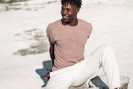 Fashionable curly black African American man posing looking at the camera in fashion and stylish...