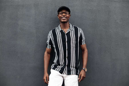 half-length portrait of an African American man looking at the camera and smiling, positive, in a shirt and shert, fashion posing, black model guyの写真素材