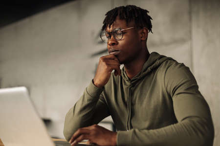African man with laptop at the table. distance communication, training. online communication. job...