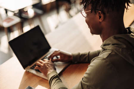 African man with laptop at the table. distance communication, training. online communication. job searchの写真素材