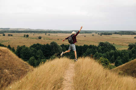 Happy free man standing alone with raised arms during a beautiful sunrise in the morning. Outdoor activities, Togetherness with nature, Travel nature, Summer vacation tripの写真素材