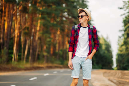 Portrait of male tourist with a backpack, Standing in the middle of the road against the background...