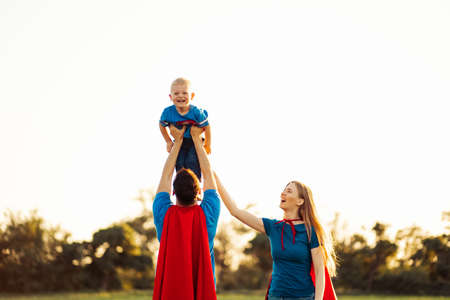 concept of european superfamily, outdoors, loving father holds on the neck, superhero family run at...