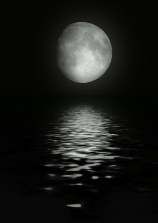 The full moon in the night sky reflected in waterの写真素材