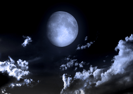 The moon in the night sky in cloudsの写真素材