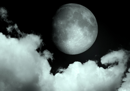 The moon in the night sky in cloudsの写真素材