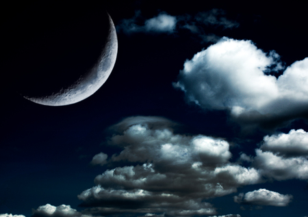 The moon in the night sky in cloudsの写真素材