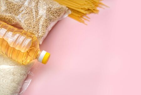 Food supply crisis food stock quarantine period isolation on a pink background. Rice, pasta, barley, butter. Food Delivery, Donation, Coronavirus Quarantine.の写真素材