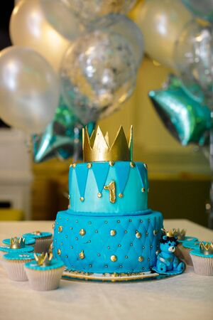 1 year birthday cake in blue with a gold crown