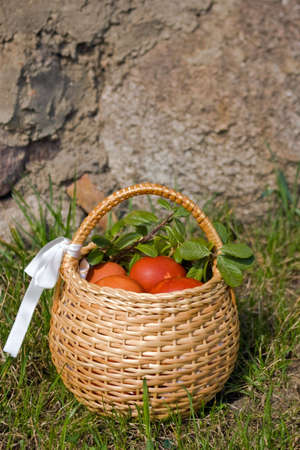 Colorful eggs in the woven basket on the stone backgroundの写真素材