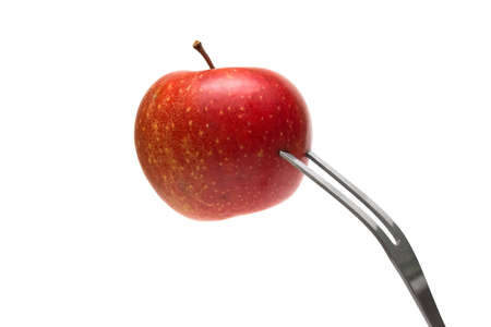 Red apple on the fork on white backgroundの写真素材