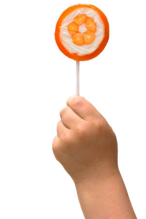 lollipop in the hand of a child on white backgroundの写真素材