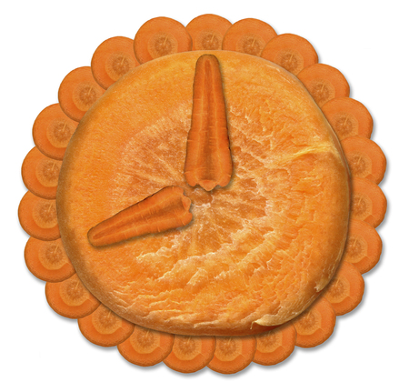 Orange watch from fresh carrots on a white background. Bright clock face, consisting of longitudinal and transverse slices of carrot.の写真素材