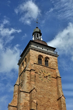 massive but slender bell tower with a clockの写真素材