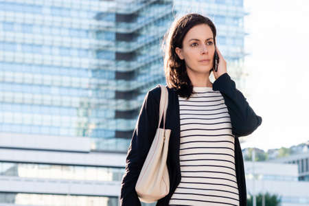 Cropped shot of an attractive young businesswoman talking on her cellphone while outside in the cityの写真素材
