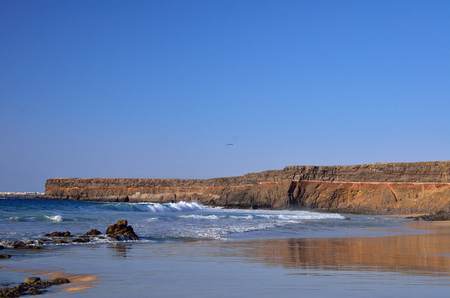 ocean beach and rock cost of island Fuerteventura and small city