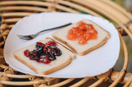 two sweet toast with fruit jam on the plate with fox at the terraceの写真素材